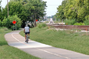 Person riding bike on bike trail next to the new TEXRail train track
